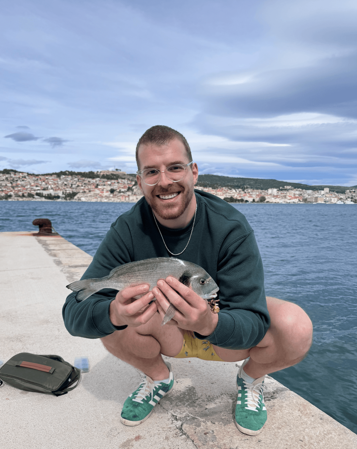 Nedim with fresh catch by the water